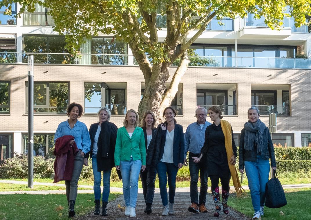 Coaches participatie en inkomen; 7 vrouwen en een man lopen in een rij over een voetpad