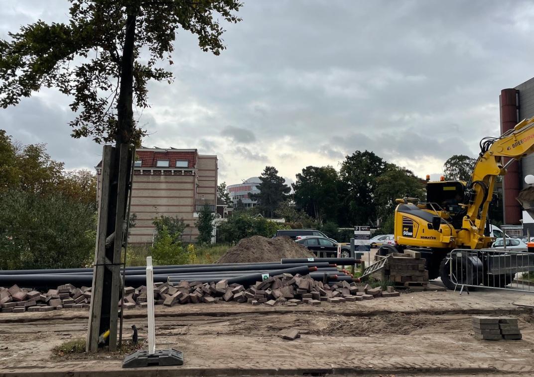 Aanleg van een warmtenet in het centrum van Amersfoort; de straat wordt opengebroken door een grote gele kraanwagen
