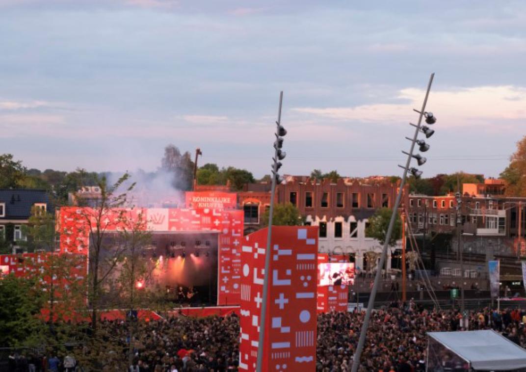 Een groot podium waar een grote mensenmenigte voor staat