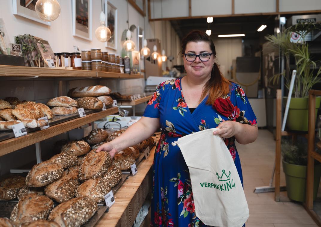 Winkeleigenaresse van bakkerij Proof Bakery met duurzame, herbruikbare broodzak naast het brood