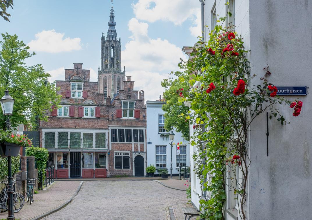 Een straat in de historische binnenstad met op de achtergron de Onze Lieve Vrouwetoren.