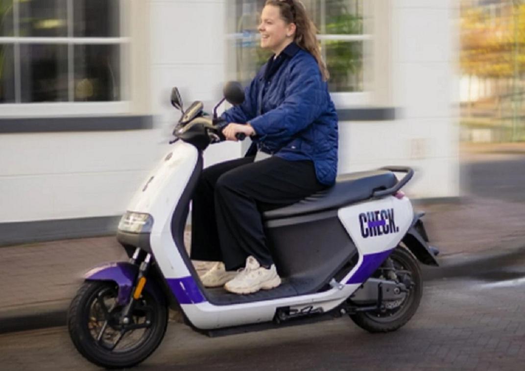 Een vrouw die op een scooter rijdt