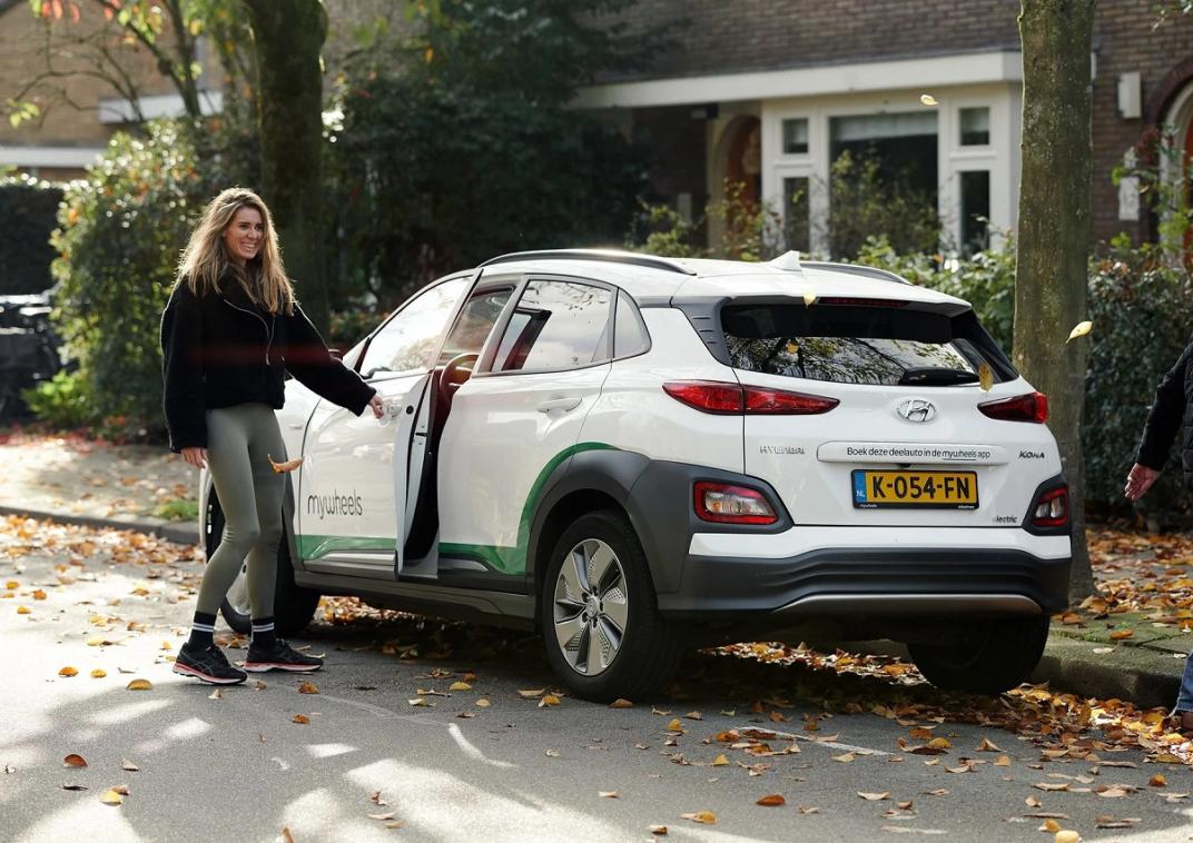 Een vrouw die bij een auto staat