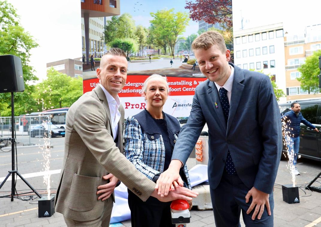 Wethouder Mobiliteit Tyas Bijlholt, regiodirecteur Harro Homan van ProRail en regiodirecteur Irma Winkenius van NS onthullen het bouwbord voor de werkzaamheden aan het stationsplein. 
