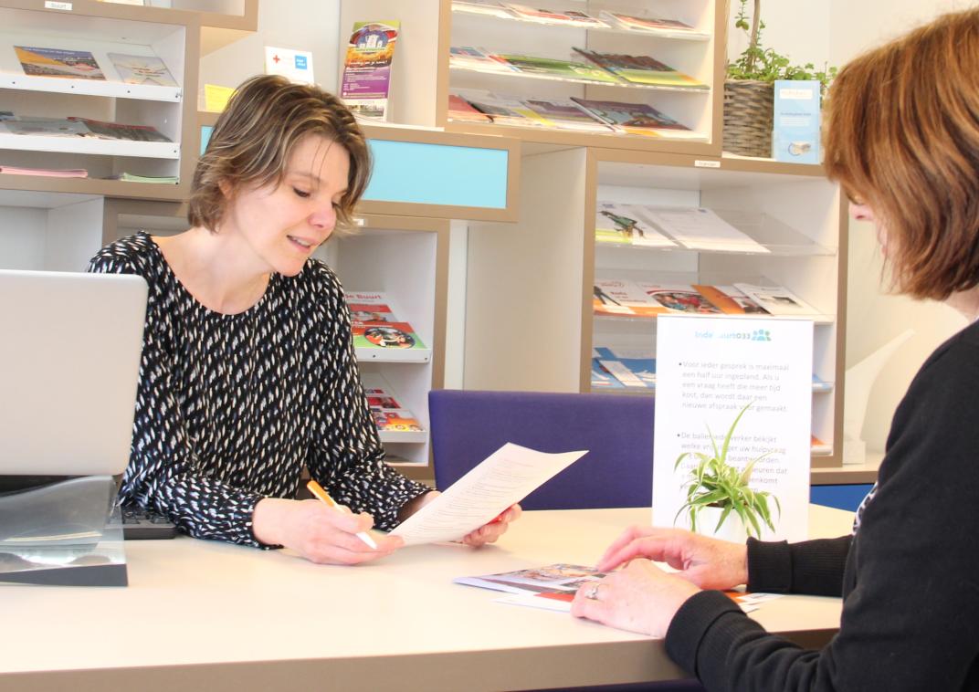 Vrouw achter een balie van Informatiewinkel Indebuurt033