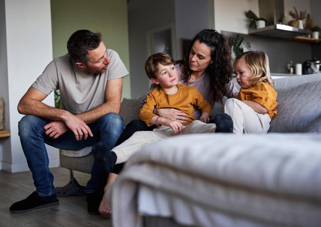 Vader, moeder en twee kinderen op de bank