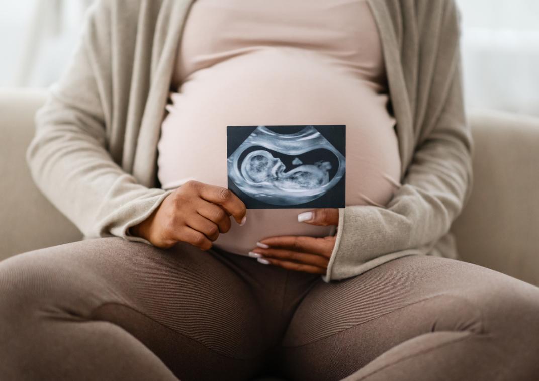 Zwangere buik met een echo van een ongeboren baby
