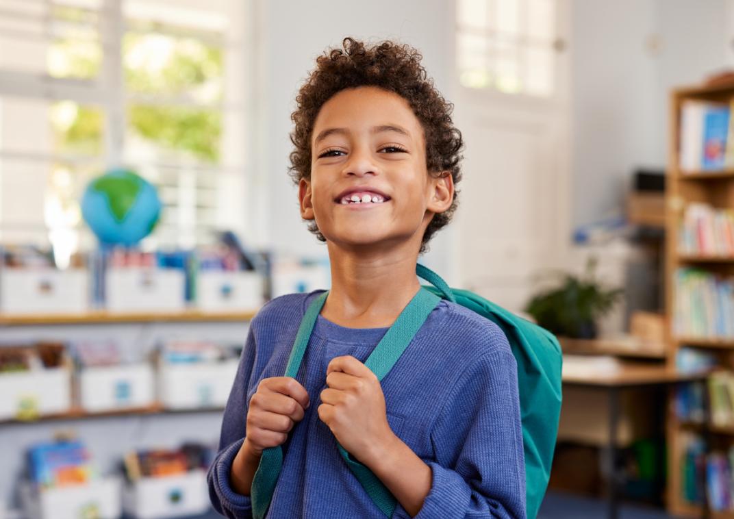 Jongetje op basisschool met rugtas