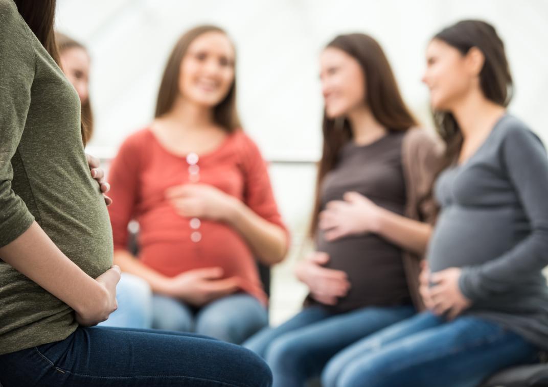 Groep vrouwen die zwanger zijn zitten in een kring