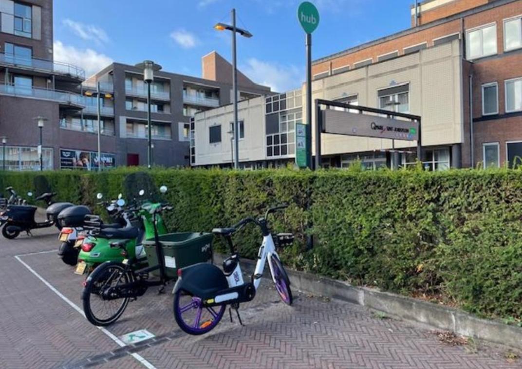 Buurthub met deelfietsen, met een paal met bord druppel/ onderbord