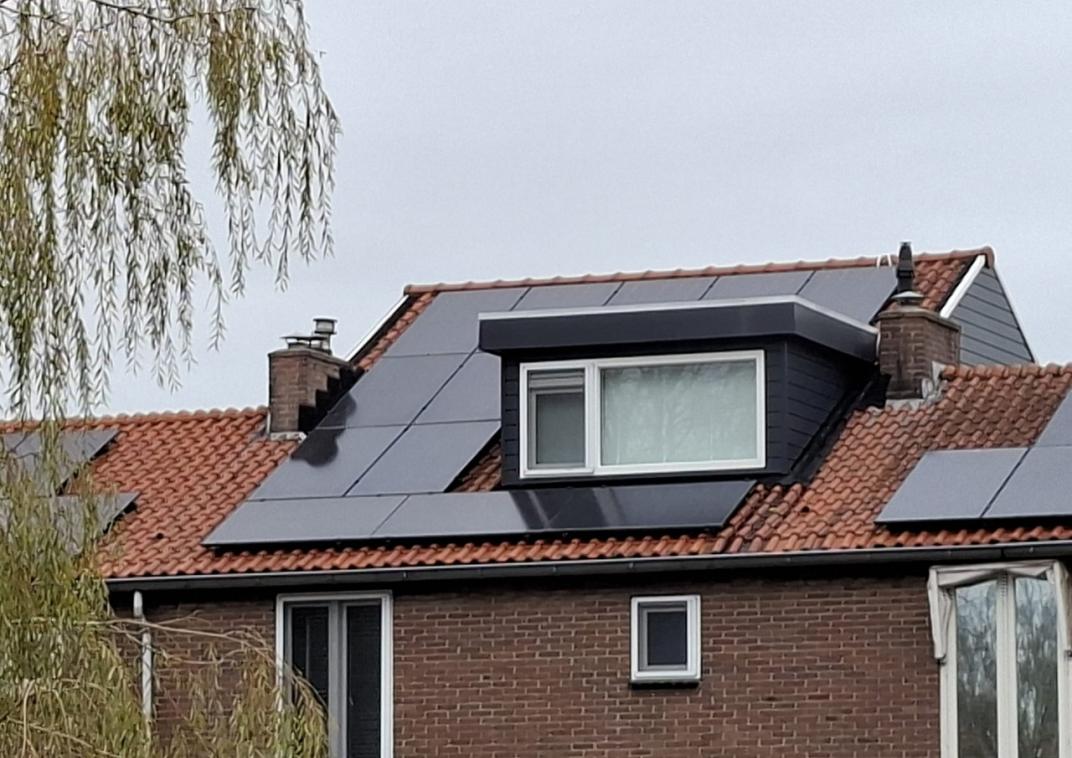 Een huis met een dakkapel en eromheen zonnepanelen