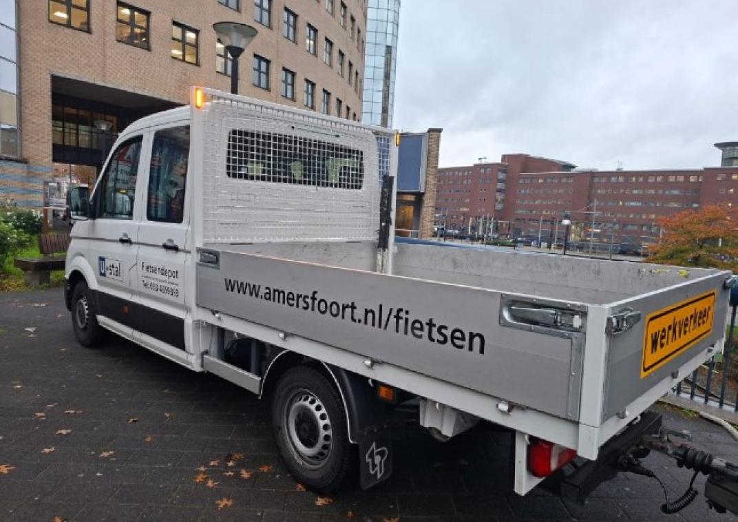 Een kleine vrachtwagen van de gemeente om verkeerd geparkeerde fietsen mee te nemen