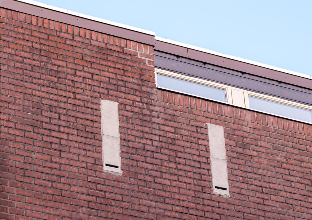 Een muur met openingen voor ingebouwde verblijfplaatsen voor vleermuizen