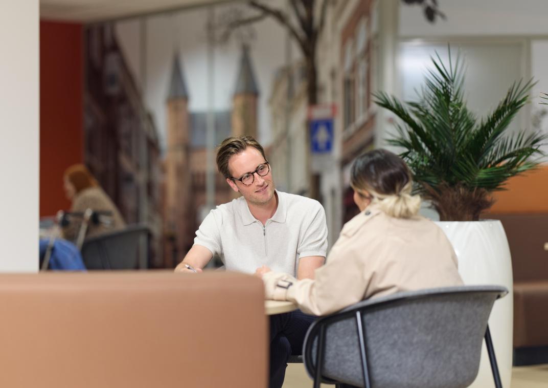 Man en vrouw praten aan een tafel