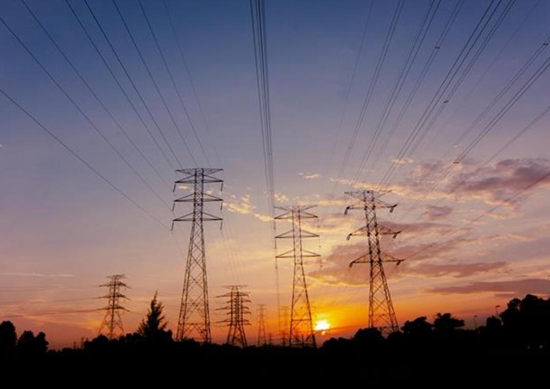 7 elektriciteitsmasten met een zonsondergang