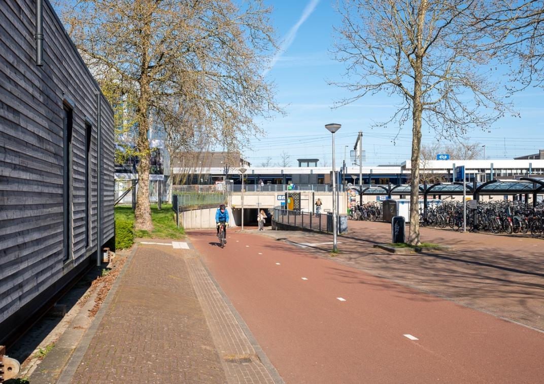 Een fietser op een speedpedelec die uit een tunnel onder het spoor rijdt