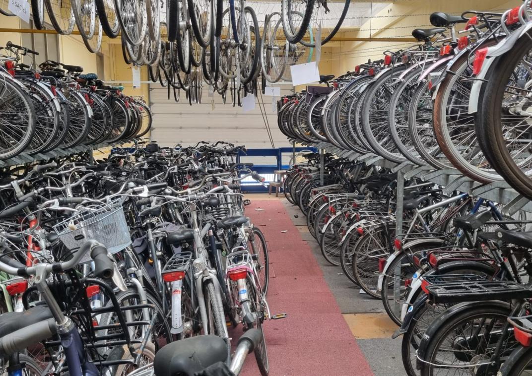 Foto van een fietsenstalling vol fietsen
