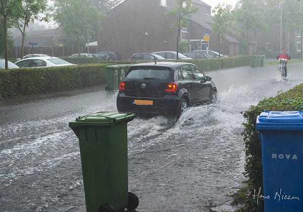 Auto rijdt door hoog water