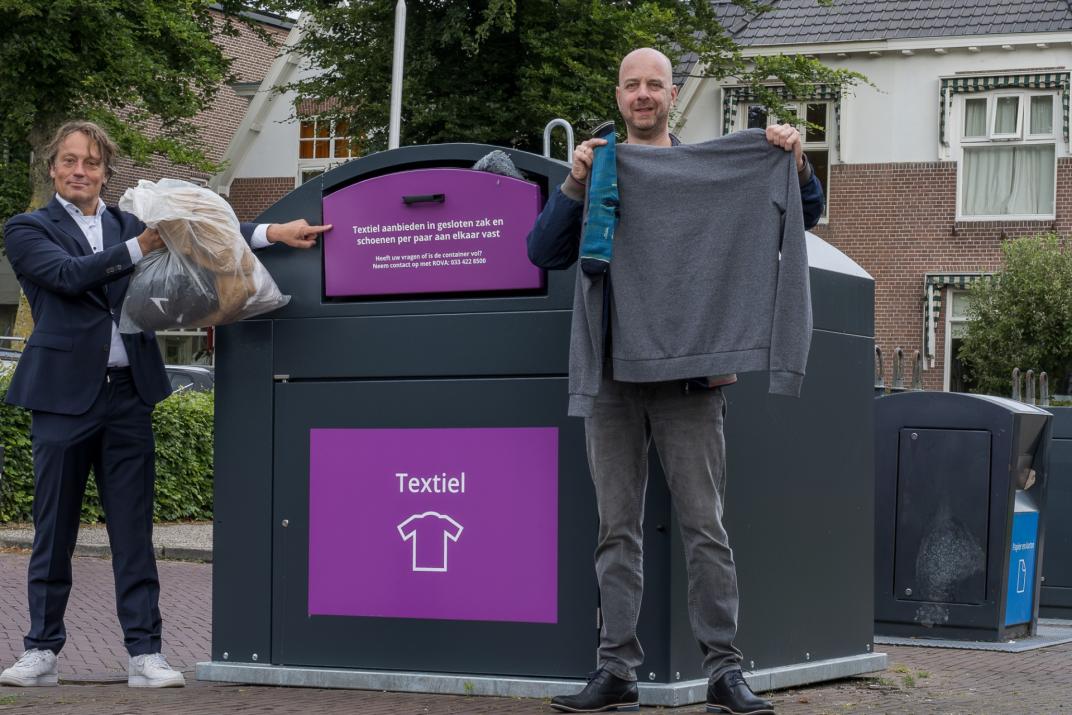 Wethouder Johnas van Lammeren en Maurits van de Kamp van Stichting Sympany bij een van de nieuwe textielcontainers.