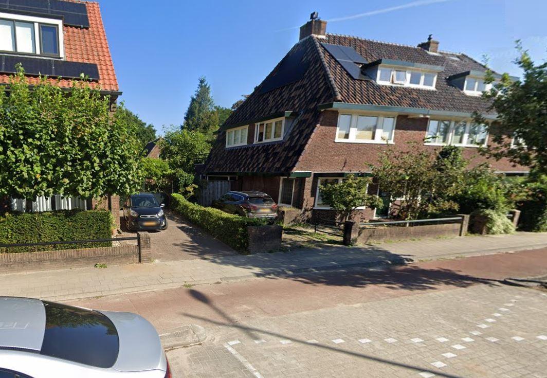Een straat met een huis met een oprit waarbij je kunt parkeren op eigen terrein (POET)