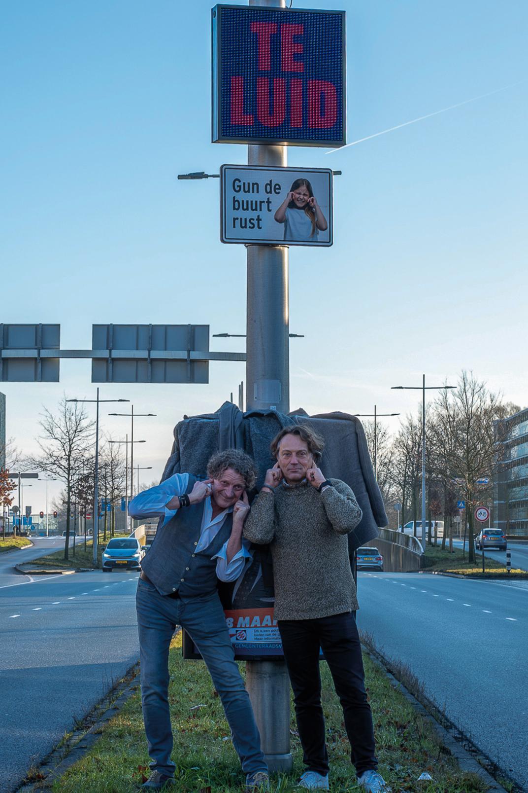 Bewoner Edo van den Brink en wethouder Van Lammeren bij het geluidsdisplay aan de Hogeweg.