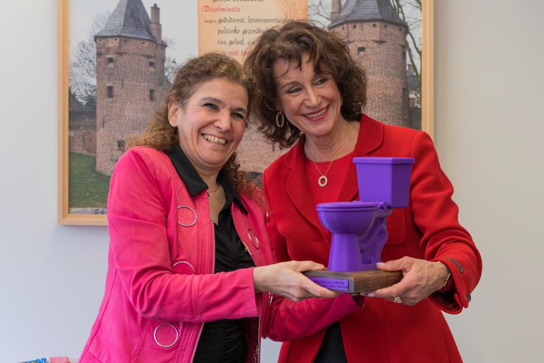 Wethouder Micheline Paffen krijgt een paars toilet overhandigd door het MDL Fonds.