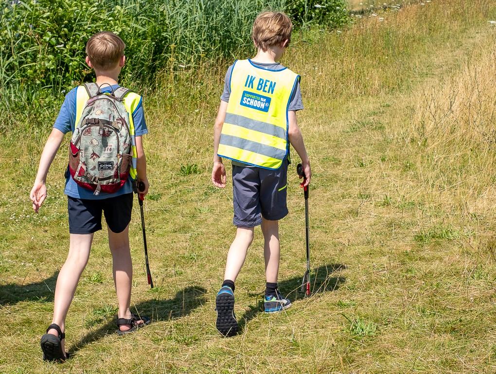 Twee kinderen die buiten meedoen met World cleanup day