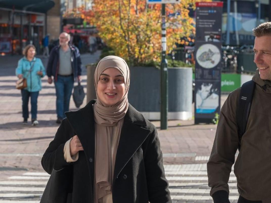 vrouw en man steken zebra over binnenstad