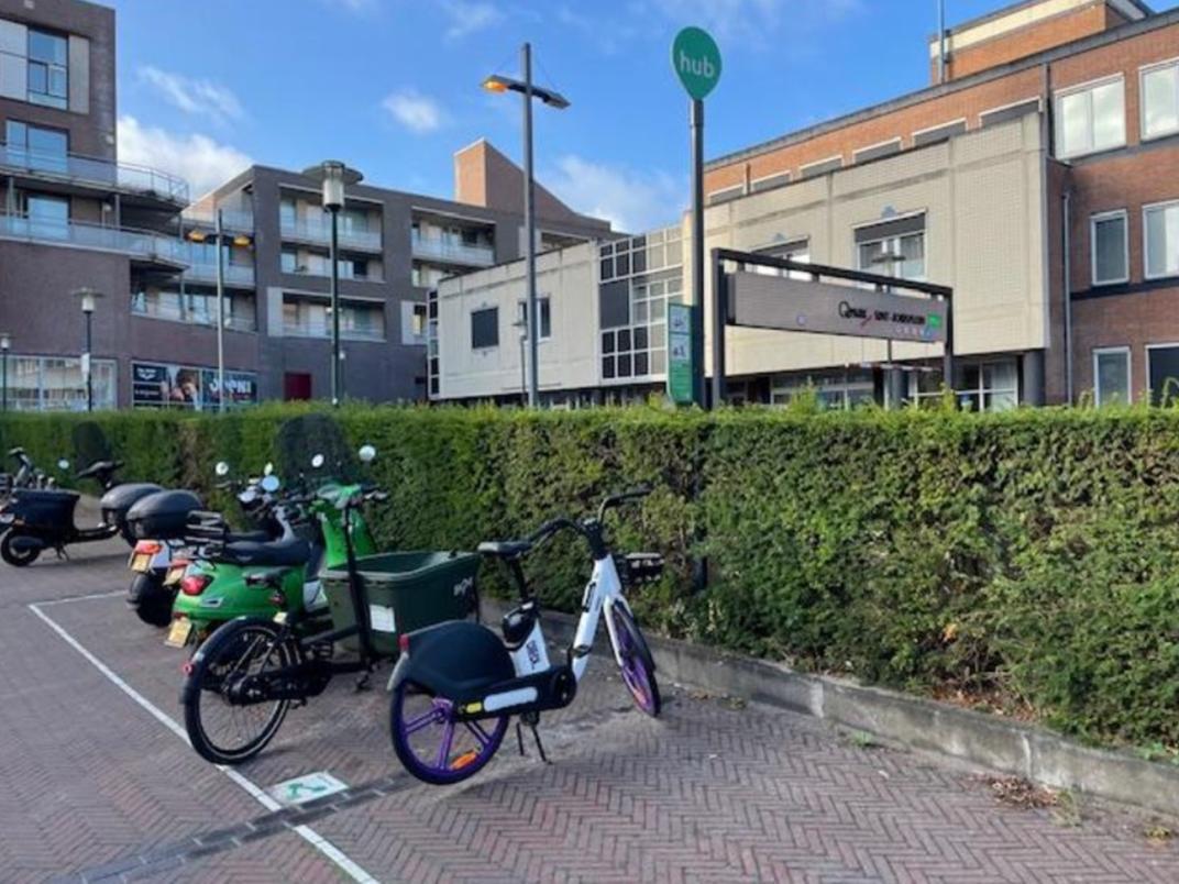Buurthub met deelfietsen, met een paal met bord druppel/ onderbord