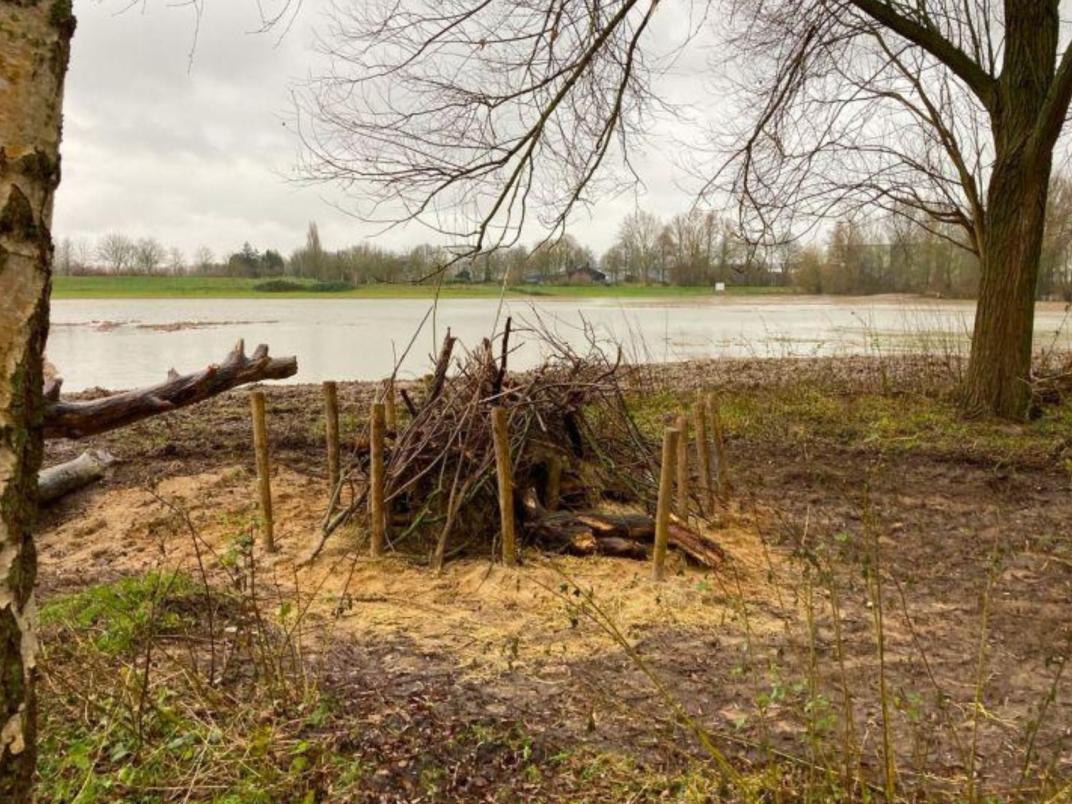 Smalle watergang of sloot met bloemrijke oevervegetatie. Natte ecologische verbindingszone in open landschap.